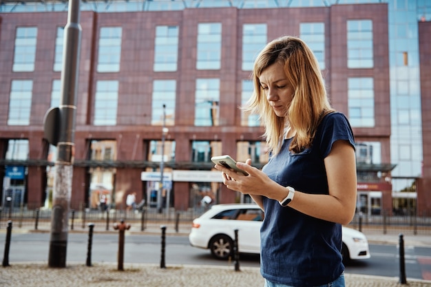 Femme utilisant un smartphone dans la rue de la ville