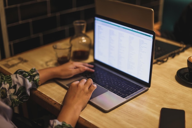 Femme utilisant son ordinateur portable dans un café. Gros plan d'une femme assise à une table avec une tasse de café et