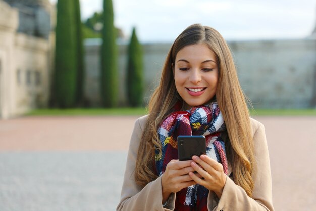 Femme utilisant son téléphone en marchant dans la ville