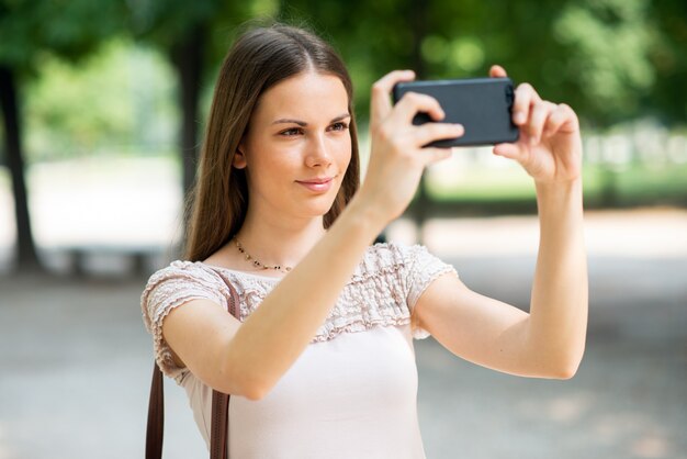 Femme utilisant son téléphone portable pour prendre une photo