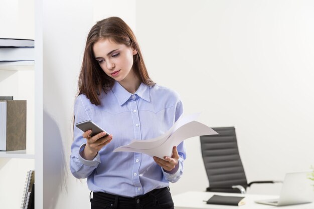 Femme utilisant un téléphone au bureau