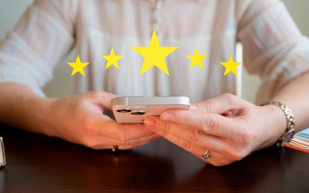 Une femme utilisant un téléphone avec cinq étoiles à l'écran