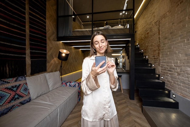 Femme utilisant le téléphone dans un appartement moderne