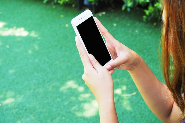 Femme utilisant un téléphone et un écran blanc. Pour le montage graphique