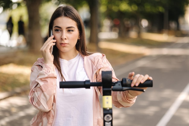 Femme utilisant le téléphone pendant la pause befour à cheval sur l'escooter