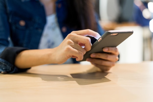 Femme utilisant un téléphone portable au restaurant