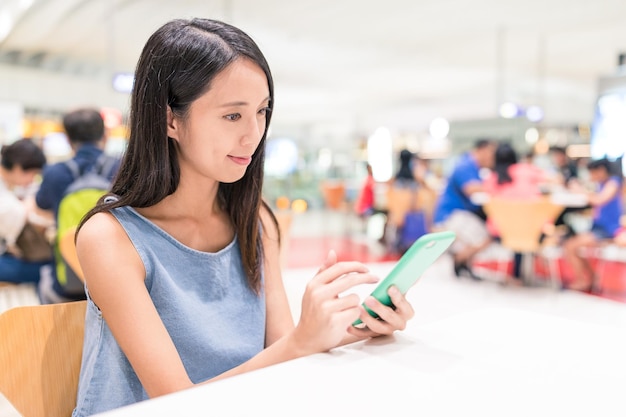 Femme utilisant un téléphone portable au restaurant