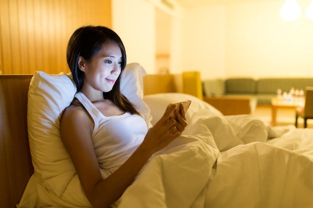 Photo femme utilisant un téléphone portable avant de dormir