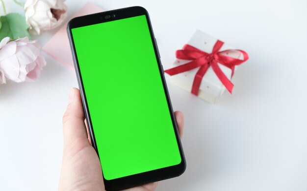 Femme utilisant un téléphone portable avec écran vert