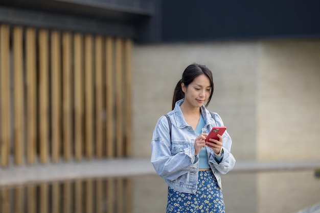 Femme utilisant un téléphone portable à l'extérieur