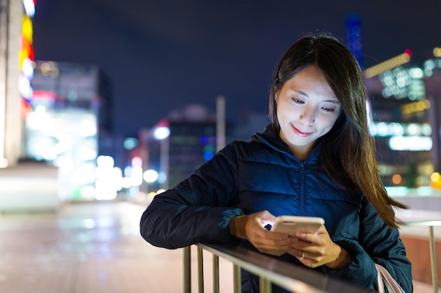 Femme utilisant un téléphone portable à l'extérieur