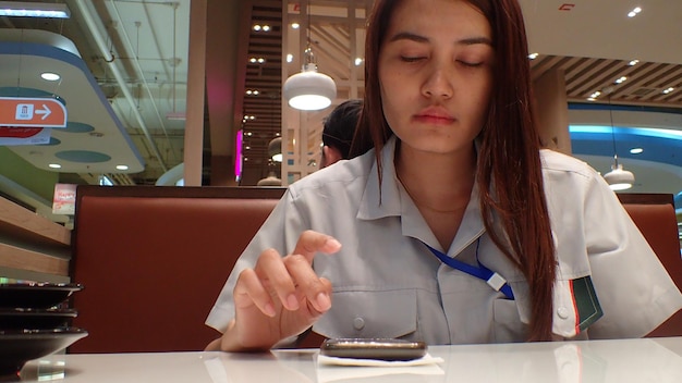 Photo femme utilisant un téléphone portable sur la table d'un restaurant