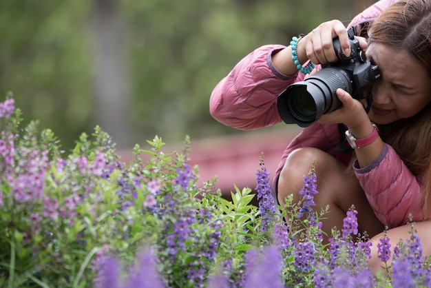 Photo femme, utilisation, appareil photo reflex numérique, fleur prenant, dans parc