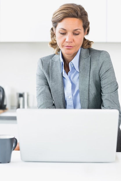 Femme, utilisation, ordinateur portable, dans cuisine