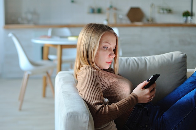 Femme, utilisation, smartphone, soir, maison, pose, Sofa