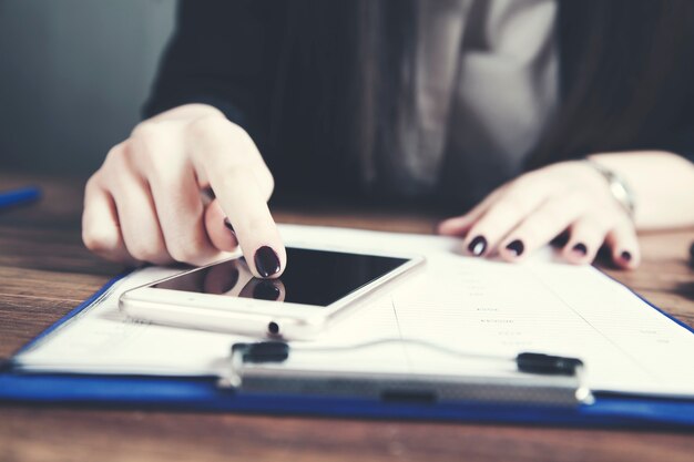 Femme, utilisation, téléphone, document, table