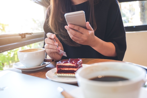 Femme, utilisation, téléphone, manger, gâteau