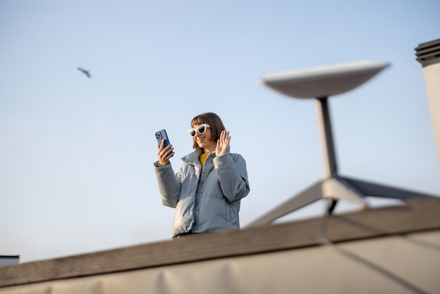 Une femme utilise une connexion Internet par satellite sur le toit d'une maison