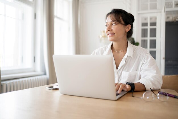 Une femme utilise un ordinateur portable au bureau Un designer indépendant réalise un projet en ligne