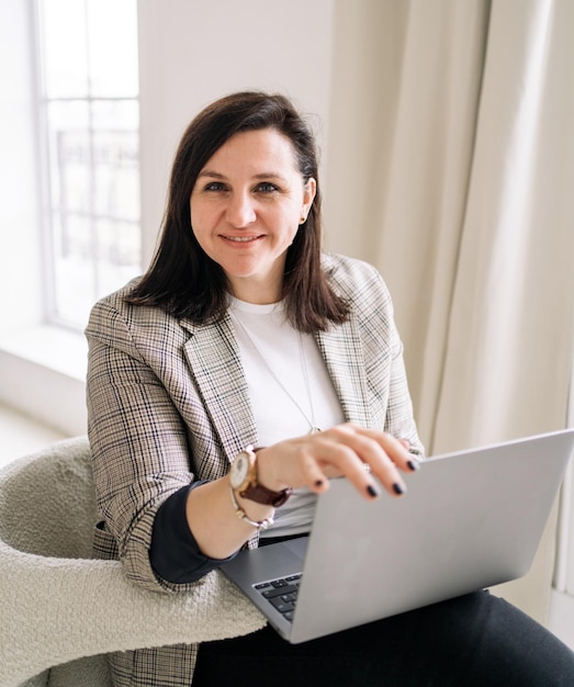 Une femme utilise un ordinateur portable au bureau sourit de bonne humeur un manager en veste