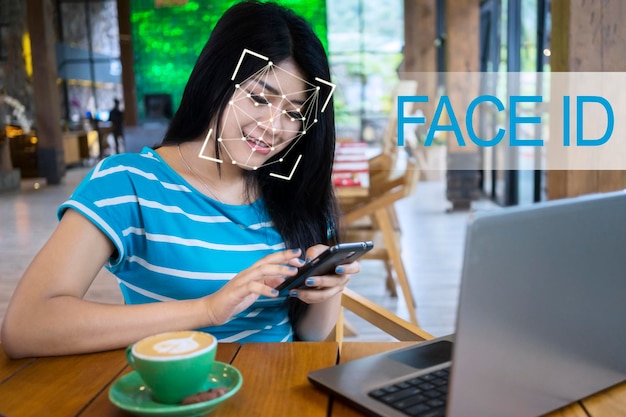 Une femme utilise la reconnaissance faciale sur son smartphone