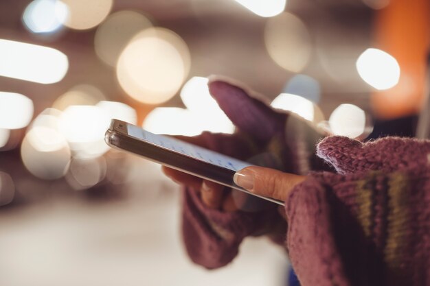 Femme utilise un smartphone la nuit dans la ville