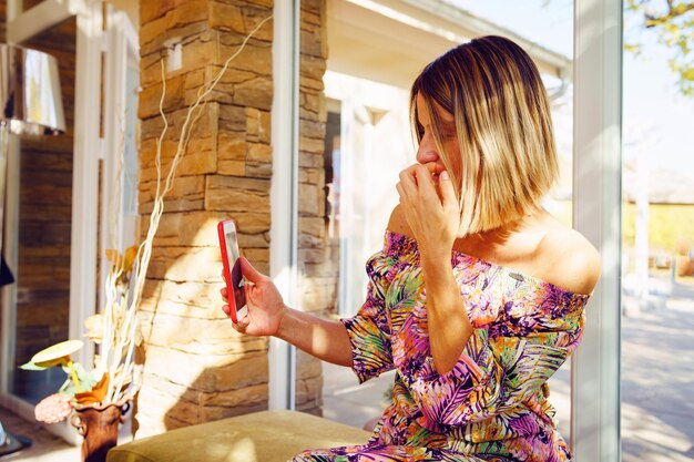 Photo une femme utilise son téléphone alors qu'elle est assise près de la fenêtre d'un restaurant.