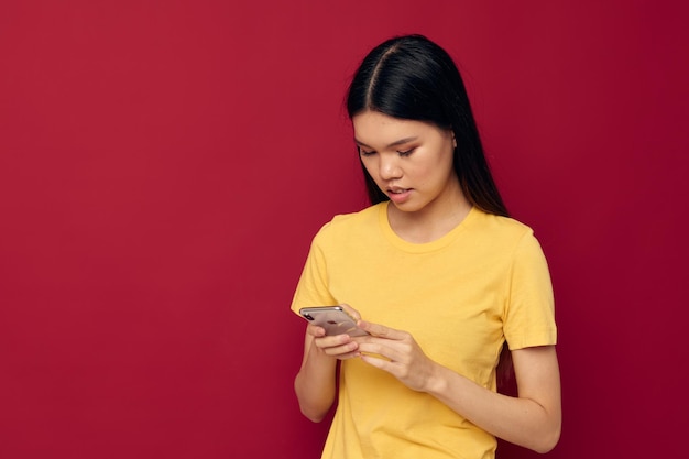 La femme utilise le téléphone sur un fond rouge