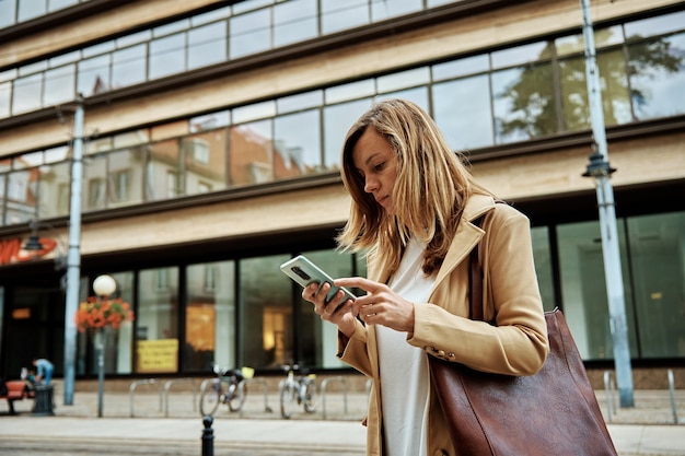 Femme utiliser un smartphone dans la rue de la ville