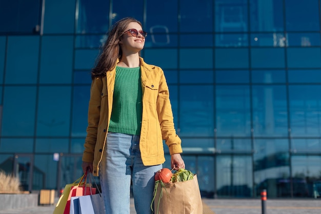 Une femme va au passage pour piétons d'un centre commercial avec un panier d'épicerie