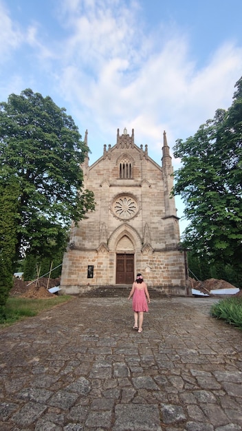 Photo une femme va au temple une grande église catholique de style gothique
