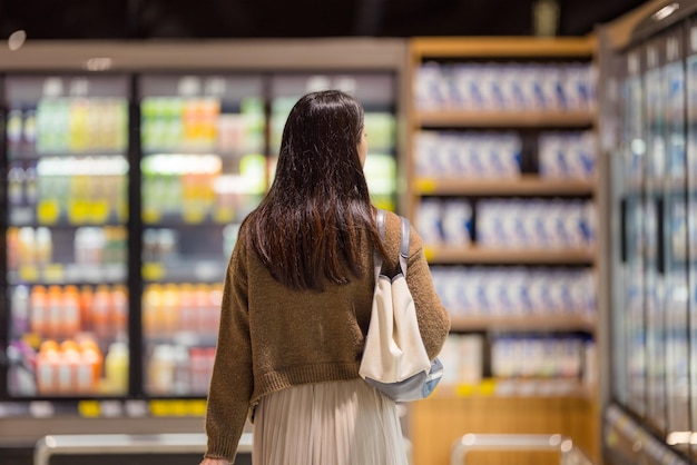 Une femme va faire ses courses au supermarché.