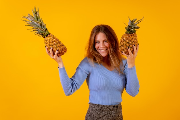 Femme végétarienne souriante avec un concept de vie saine et de fruits tropicaux d'ananas coupé