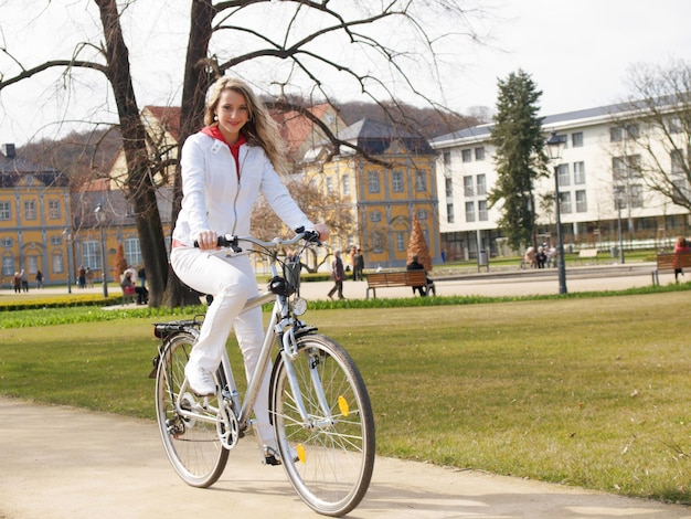 une femme sur un vélo avec un costume blanc