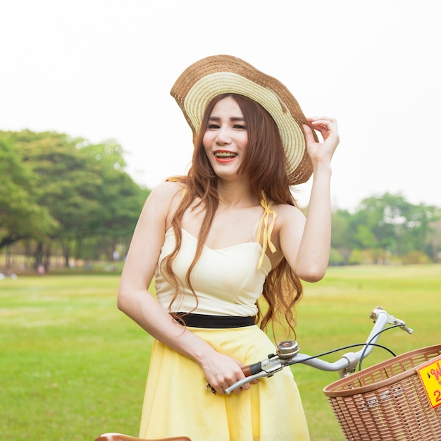 Femme avec vélo sur la pelouse