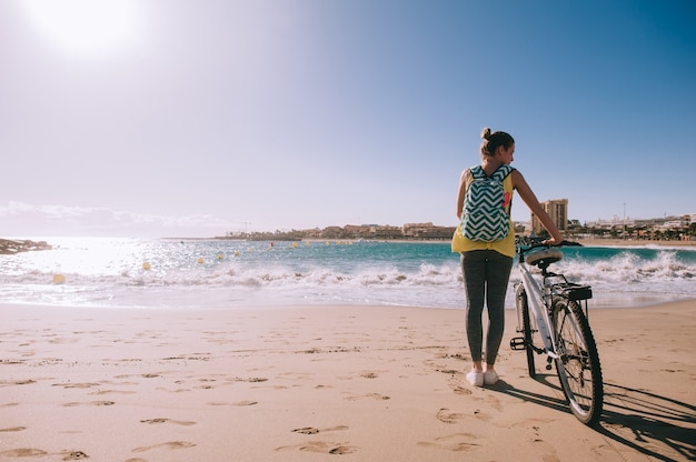 Femme à vélo sur la plage