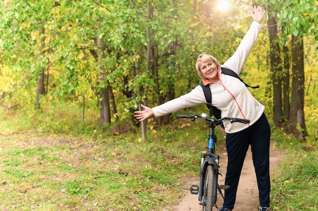 Une femme sur un vélo se promène sur la route dans le parc de la ville