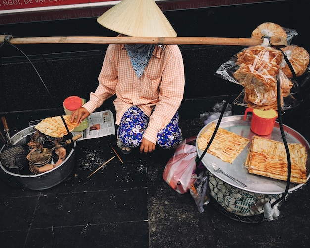 Photo une femme vendant de la nourriture sur le trottoir.