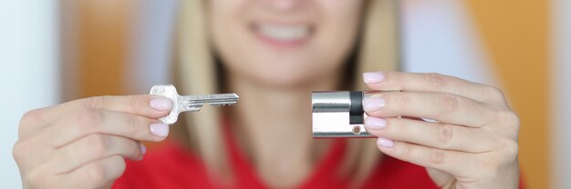 Femme vendeur détient la clé et le trou de la serrure dans ses mains gros plan.