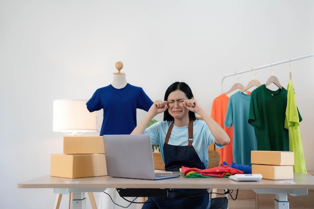 Femme vendeuse PME propriétaire d'un magasin de détail travaille dur s'inquiète du stress dans les mauvaises nouvelles sur un ordinateur portable au bureau à domicile Les Asiatiques crise tailleur problème d'emploi se sentent fatigués et bouleversés par la perte d'argent en espèces ou la dette de prêt