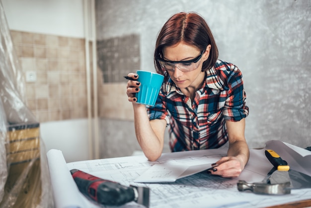 Femme vérifiant le projet de la nouvelle cuisine