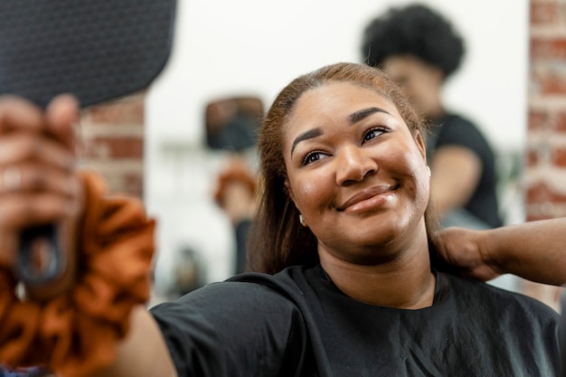 Femme vérifiant sa nouvelle coiffure dans un miroir