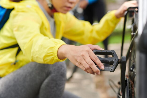 Femme vérifiant la transmission du vélo