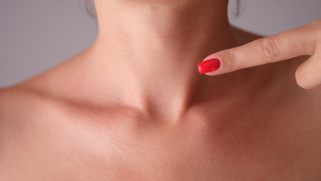 Une femme vérifie manuellement la glande thyroïde dans le cou en gros plan