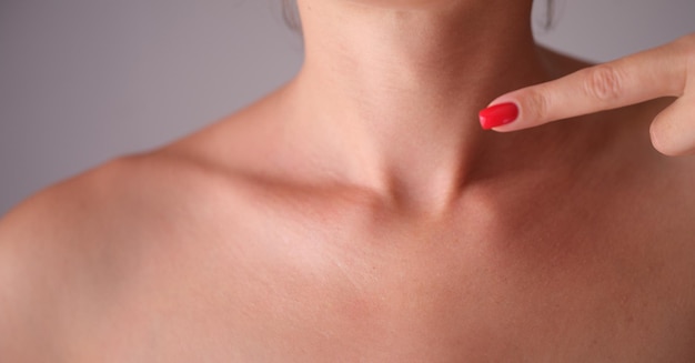 Une femme vérifie manuellement la glande thyroïde en gros plan du cou
