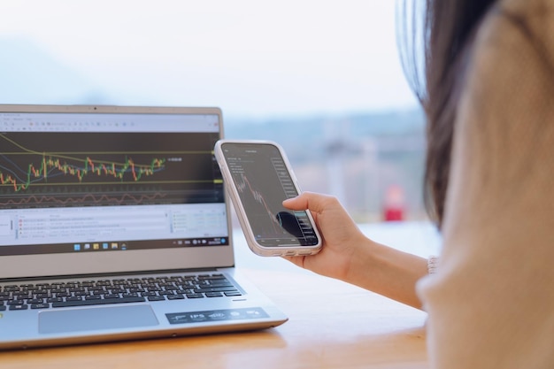 Photo une femme vérifie le tableau des prix bitcoin sur l'échange numérique sur la prédiction de l'action future des prix de la crypto-monnaie du smartphone