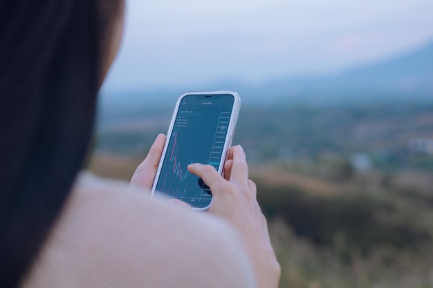 Photo une femme vérifie le tableau des prix bitcoin sur l'échange numérique sur la prédiction de l'action future des prix de la crypto-monnaie du smartphone