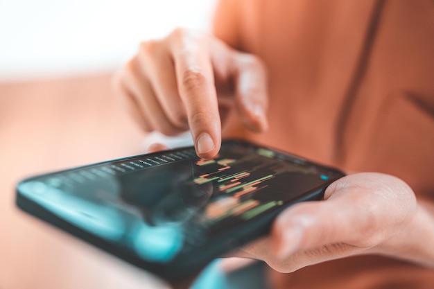 Une femme vérifie le tableau des prix Bitcoin sur l'échange numérique sur smartphone