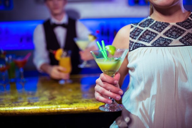Femme, à, verre cocktail, debout, par, barman