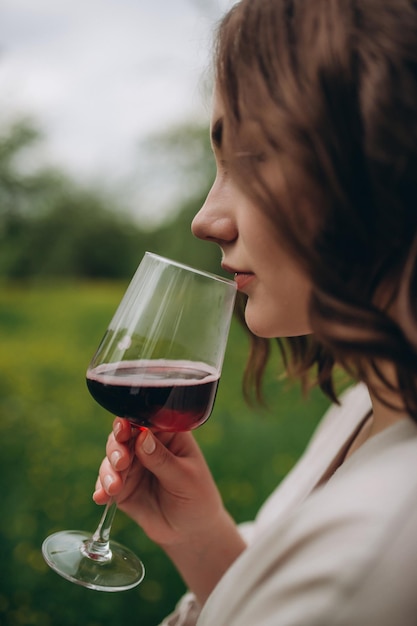 Femme avec un verre de vin savoureuxJeune femme buvant du vin